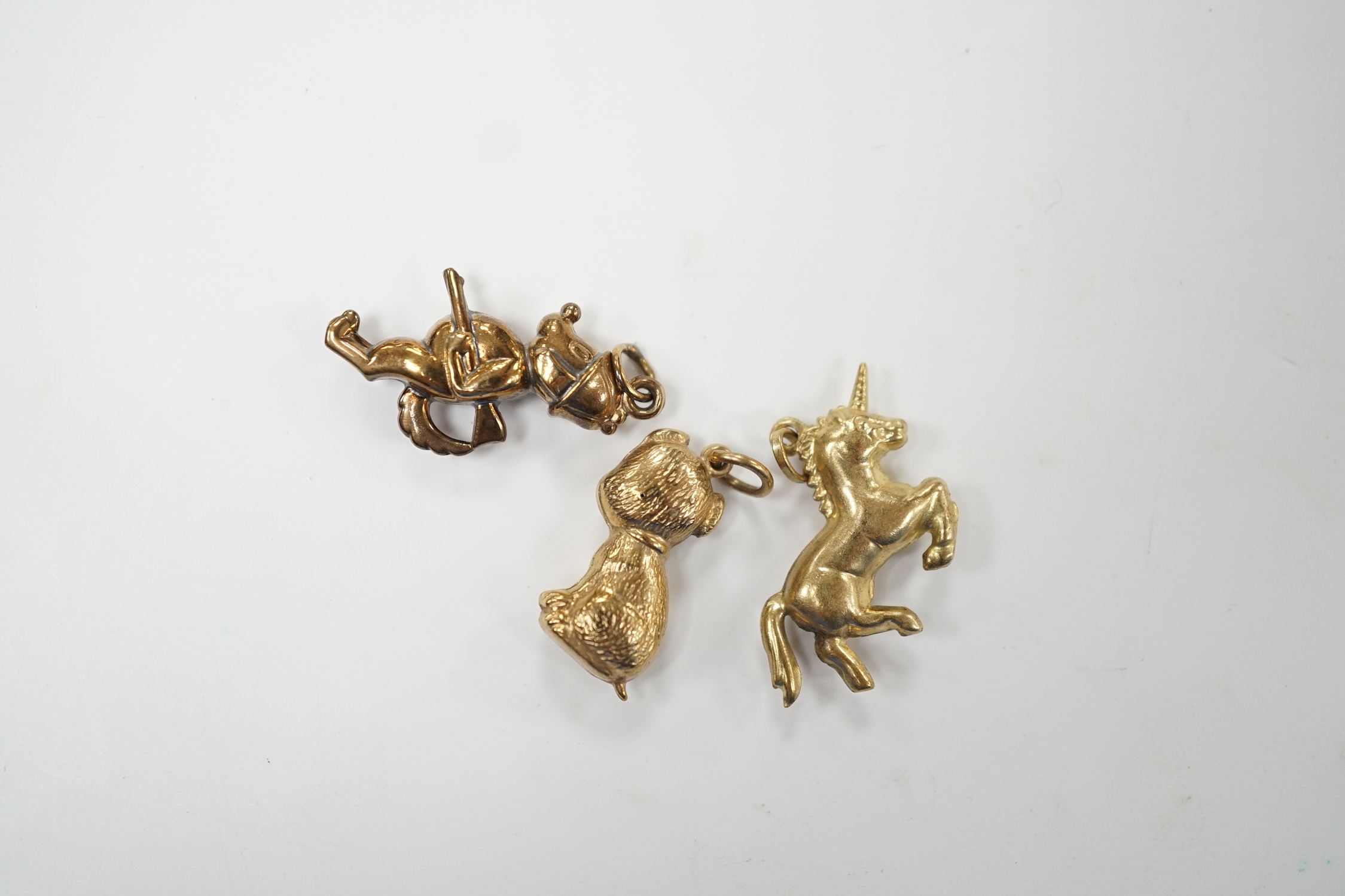 Two 9ct gold charms including 'gun dog', 24mm and a yellow metal unicorn charm. Good condition.